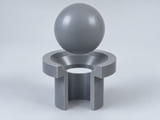 CGI conceptual: esfera completa de cloruro de polivinilo rígido; formulación y restricciones de plastificantes definidas, sobre un asiento anular cónico y un orificio vertical abierto alineado; concepto de contacto axial entre componentes