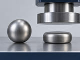 CGI conceptuelle : sphère en acier doux complète à côté d'un échantillon du même matériau volontairement aplati ; comparaison de formage