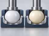 CGI conceptuelle : sphère blanche en POM dans une coupelle de siège mécanique léger, à côté d’une sphère ivoire en nylon dans une seconde coupelle identique ; jeu de fonctionnement visible et géométrie de contact polie, sans affirmation d’essai